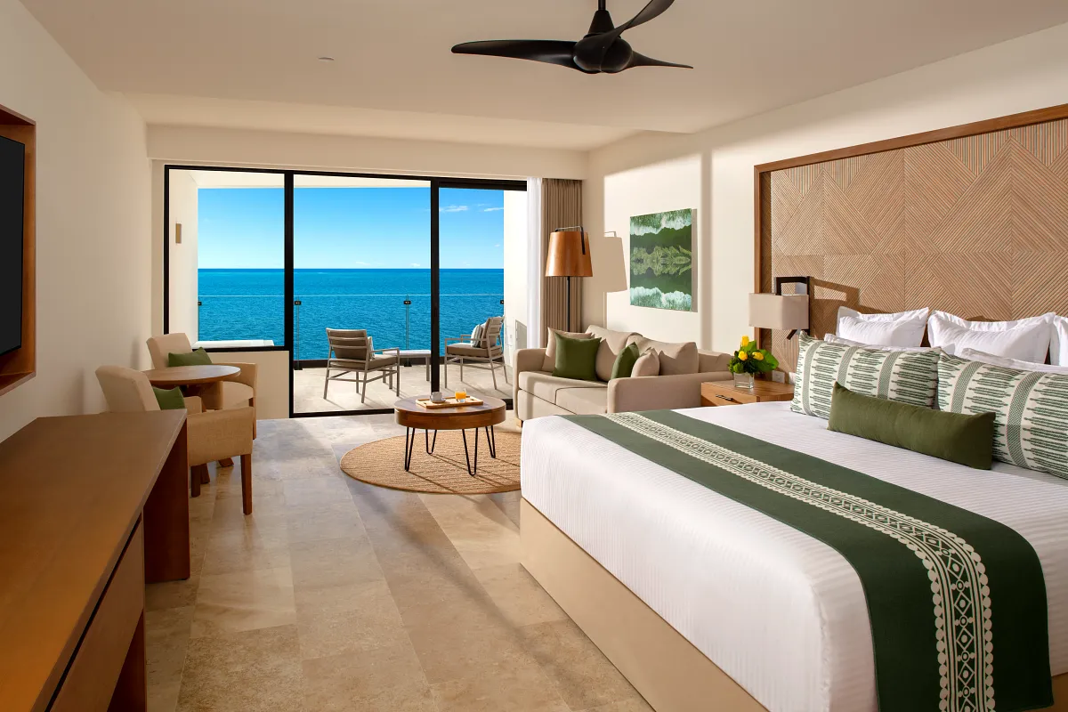A single bed ocean front suite with an ocean view in the background.