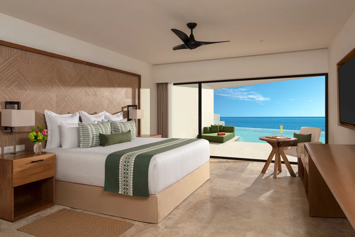 Single bed ocean front suite with a swim up pool patio in the background.