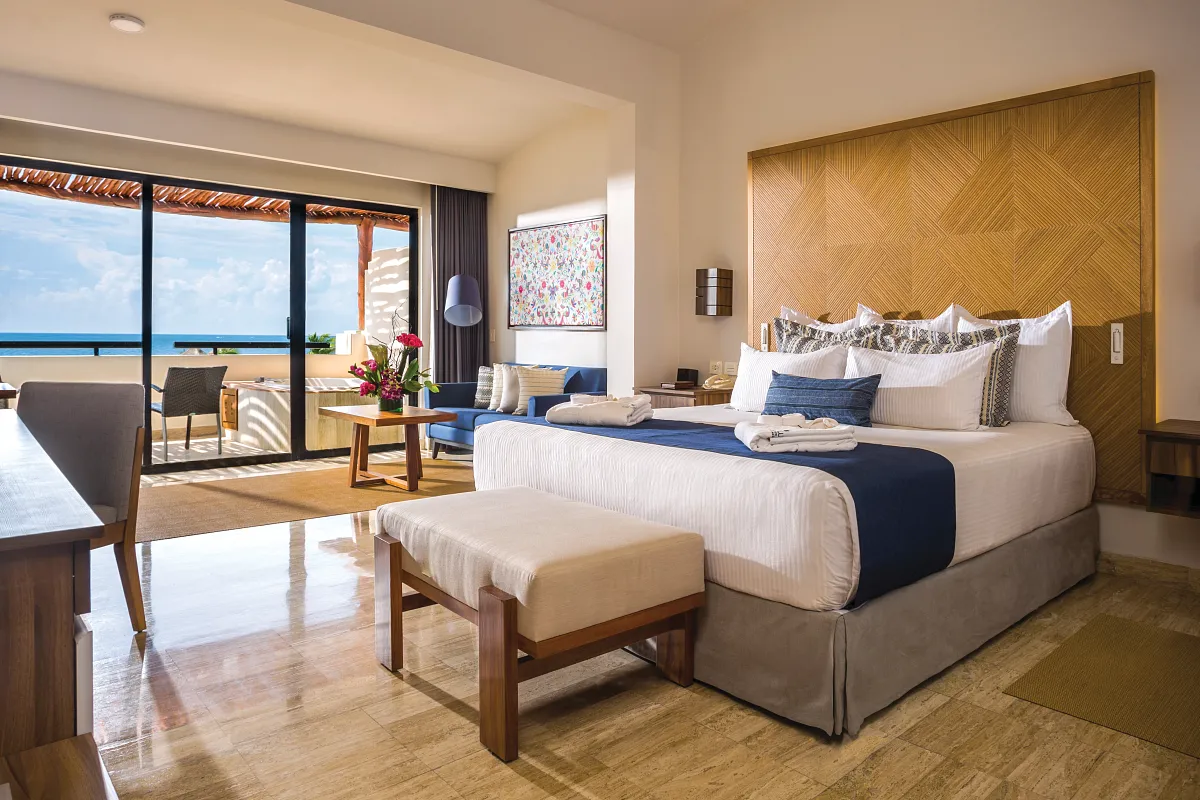 A single bed ocean front suite with an ocean view in the background.
