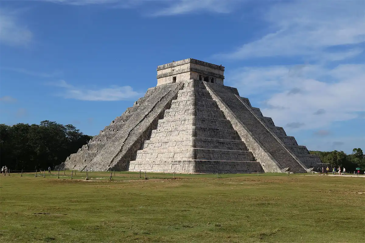 A mayan pyramid in the middle of a field.