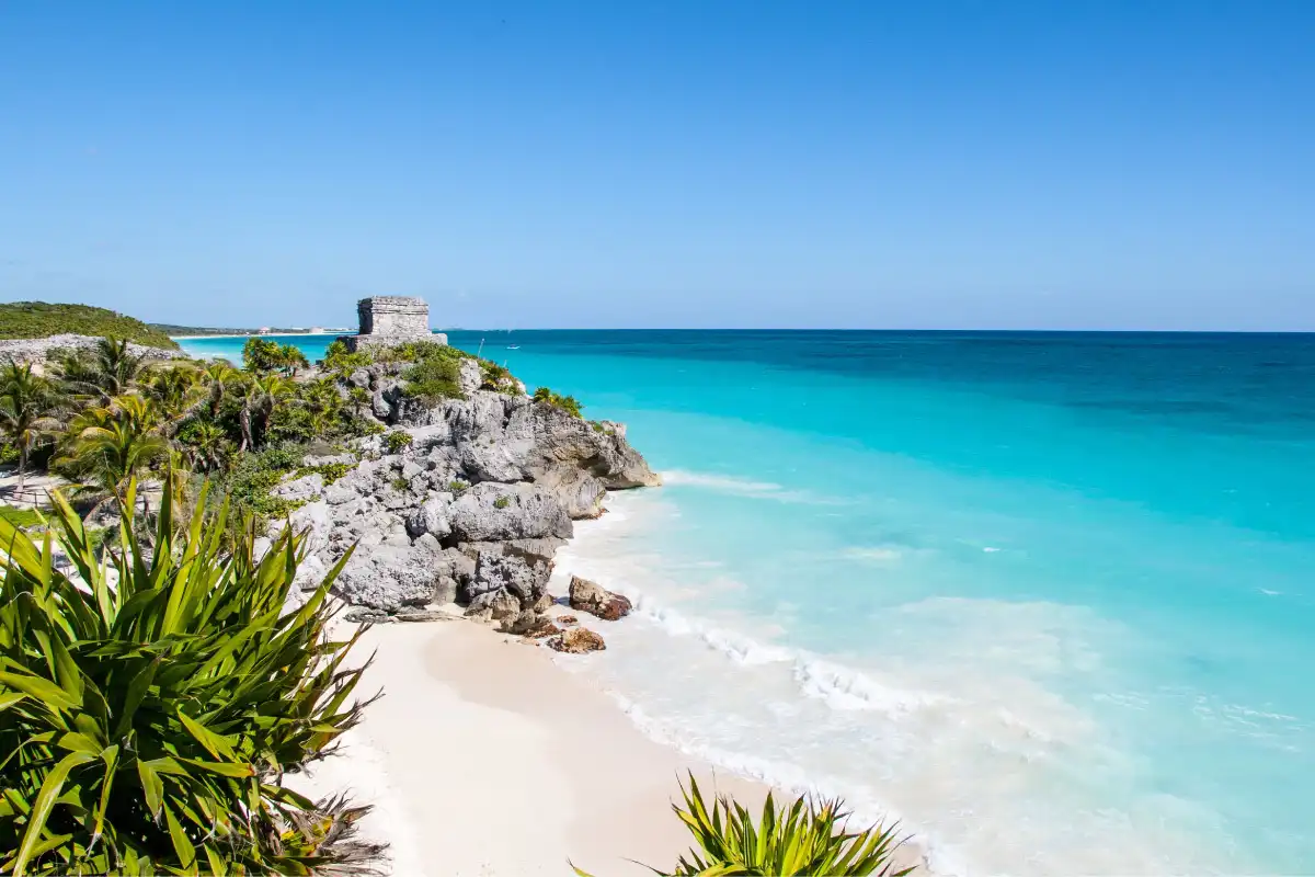 A hidden beach with a rocky temple structure in the background.