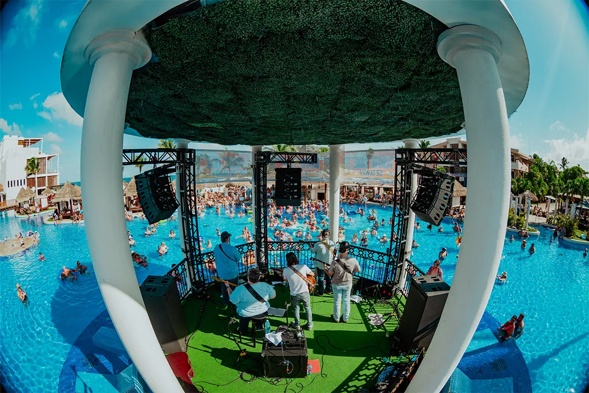A photo from behind the band on the Poolside Gazebo stage, looking out towards the crowd floating around it.