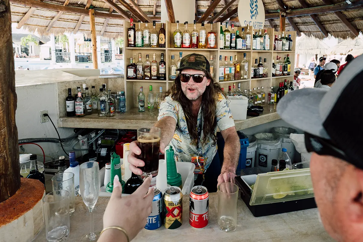 A member of Blackberry Smoke behind the bar making drinks for guests.